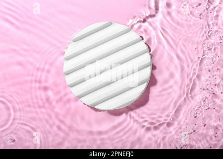 Plaster podium in water on pink background Stock Photo