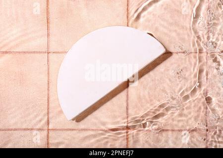 Plaster podium in water on pink tiled background Stock Photo