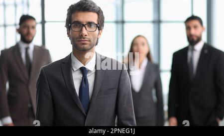 company workers standing in a row in creative office, posing on camera Stock Photo