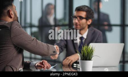 Two employees in a modern officeworking at a table, colleagues discussing and consulting, Stock Photo