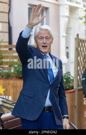 Former US President Bill Clinton waves to as he walks out of the Guildhall Taphouse after having a pint of Guinness with SDLP leader Colum Eastwood MP, after giving a speech at a posthumous tribute for two of the main architects of the Good Friday Agreement, the late John Hume and former first minister of Northern Ireland David Trimble, in the Guildhall in Londonderry. The tribute comes on the second day of a three-day international conference marking the 25th anniversary of the Belfast/Good Friday Agreement. Picture date: Tuesday April 18, 2023. Stock Photo