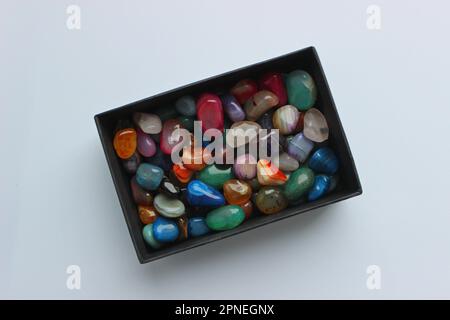 Bunch of raw semi-precious colored quartz stones in a black box top view Stock Photo