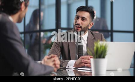 Two medium focused business workers communicate in the office. Stock Photo