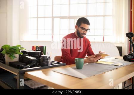 Creative man photographer working at spacious modern studio Stock Photo