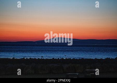 Heysham Lancashire, U Nited Kingdom. 18th Apr, 2023. Black Combe in cumbria back light by this evenings aftre glow seen from Morecambe Credit: PN News/Alamy Live News Stock Photo