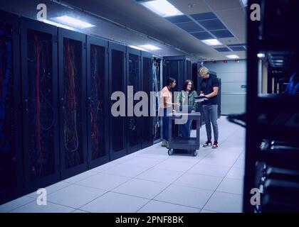 Team of technicians working in server room Stock Photo