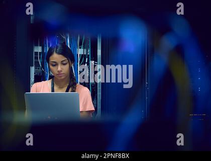 Female technician using laptop in server room Stock Photo