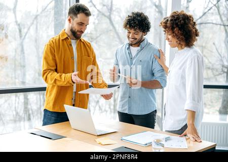 Successful multiracial business partners gathered in meeting room, businesspeople discuss new project, creative ideas, promotion strategy, financial risks and profits. Teamwork, collaboration concept Stock Photo