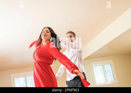 Cheerful couple dancing in apartment Stock Photo