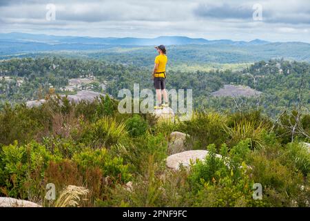 Australia, New South Wales, Bald Rock National Park, Man standing on rock and looking around Stock Photo