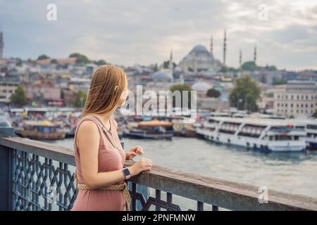 Young tourist woman on Galata bridge, Golden Horn bay, Istanbul. Panorama cityscape of famous tourist destination Bosphorus strait channel. Travel Stock Photo