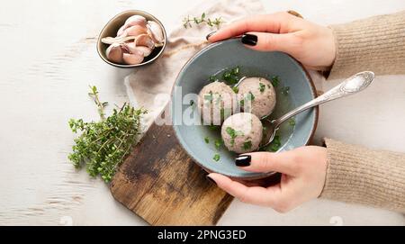 Canederli or Knodel in broth with green onion, typical pasta or dumplings for Alps, Alto Adige, German, Italian, Austrian cuisine. Made from stale bre Stock Photo