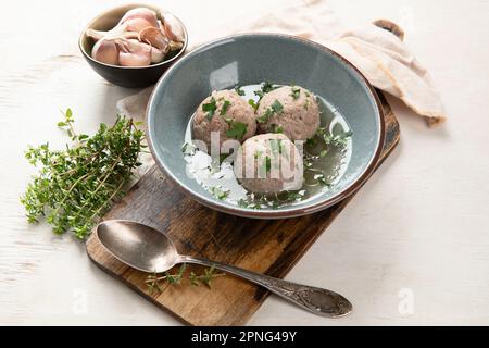 Canederli or Knodel in broth with green onion, typical pasta or dumplings for Alps, Alto Adige, German, Italian, Austrian cuisine. Made from stale bre Stock Photo