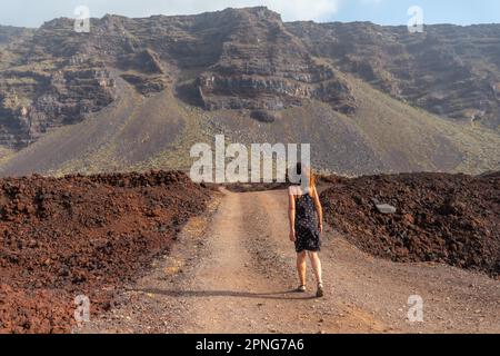El Hierro Island. Canary Islands, tourist woman in the Arco de la Tosca walking on a volcanic path along the coast Stock Photo