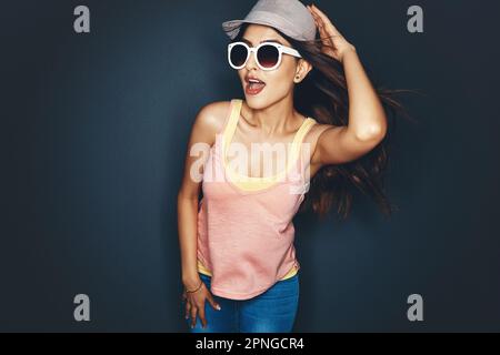 I cant hear you over the sound of my awesomeness. Studio shot of an attractive and fun loving young woman posing against a dark background. Stock Photo