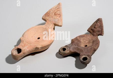 Two Roman era terracotta oil lamps 1st century CE one nozzle on the left and two nozzle sample on the right Stock Photo
