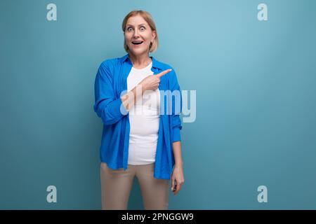 smart mature woman thinking brilliant idea on blue background with copyspace Stock Photo