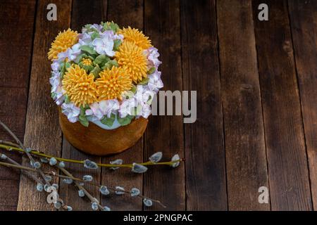 Easter cake on a wooden table decorated with cream flowers, close-up, traditional treat. Easter Holiday Stock Photo
