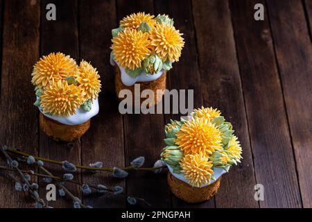Easter cake on a wooden table decorated with cream flowers, close-up, traditional treat. Easter Holiday Stock Photo