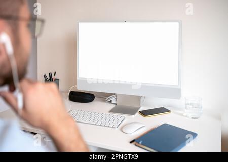 Blank computer screen on desk at office, male person looking at pc monitor Stock Photo