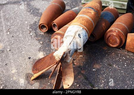 Waste of war. Few rusty used missiles on gray asphalt background Stock Photo
