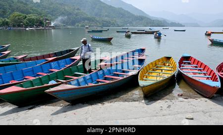 Colorful traditional boats on the shore of lake Phewa, Nepal, that are mainly used for boat rides and touristic purposes. Stock Photo