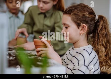 Happy children learning how to take care about plants. Stock Photo