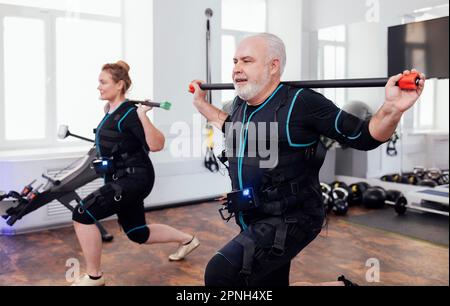 EMS electro stimulation women exercises with coach in modern gym. Electric muscle  stimulation workout Stock Photo - Alamy