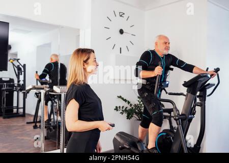 EMS electro stimulation women exercises with coach in modern gym. Electric muscle  stimulation workout Stock Photo - Alamy