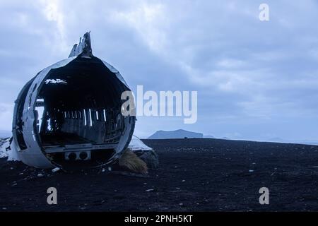 Iceland - August 2021: Blue view of the old crashed plane wreck abandoned in a remoted black sand beach in iceland Stock Photo