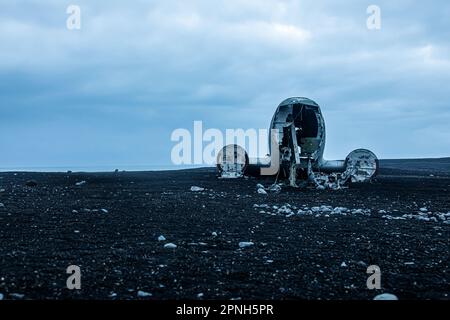 Iceland - August 2021: Night view of the old crashed plane wreck abandoned in a remoted black sand beach in Iceland Stock Photo