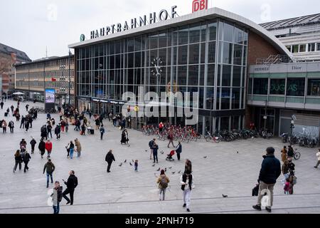 People on the plaza outside Cologne Central Station on 6th April 2023 in Cologne, Germany. Köln Hauptbahnhof or Cologne Central Station is an important local, national and international transport hub, with many ICE, Thalys and Intercity trains calling there, as well as regional Regional-Express, RegionalBahn and local S-Bahn trains. Stock Photo