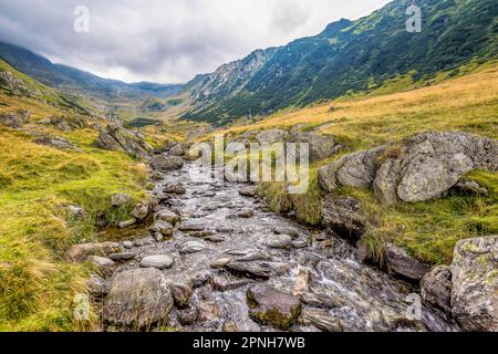 Scenic view of Transylvanian Alps in Romania against dramatic stormy clouds Stock Photo