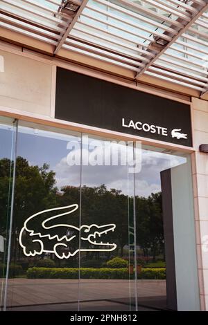 Ho Chi Minh City, Vietnam - March 28, 2023: Fashion store commercial sign with black and white Lacoste logo. Famous luxury fashion brand logotype on a Stock Photo