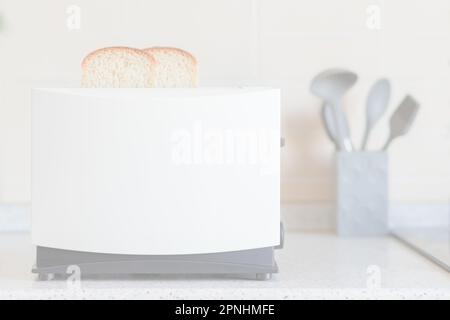 Light overexposed kitchen background with toaster and kitchen utensils on the table Stock Photo