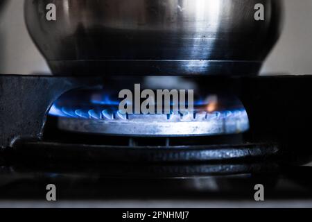 Flame from natural gas on a stove burner with a cooking pot Stock Photo
