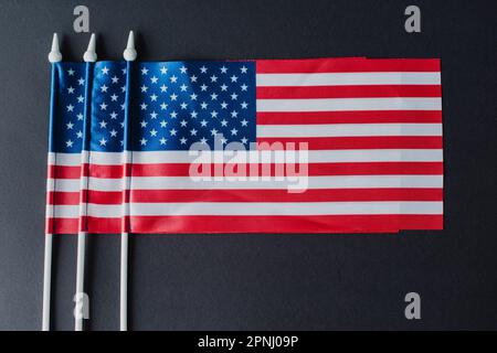 flat lay of three American flags with stars and stripes isolated on black Stock Photo