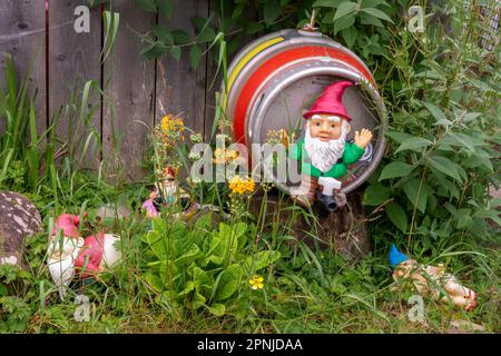 Funny garden gnome sitting on a keg of beer Stock Photo