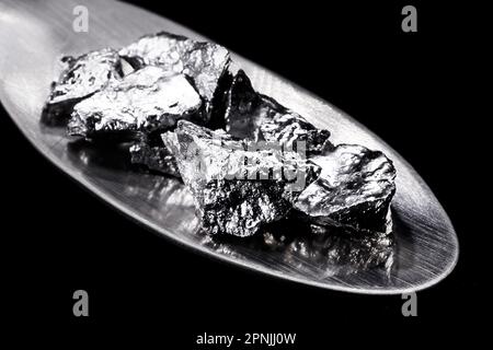 Chromium fragments on trowel, industrial use ore, metallic chemical element, isolated on black background Stock Photo