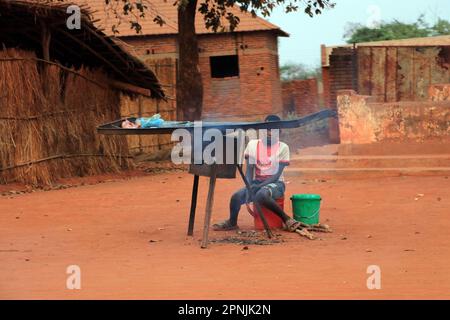 A young boy is seen preparing chips for sale on the roadside in Malingunde Malawi. The chips are called 'chips yepachiwaya'. Malawi. Stock Photo