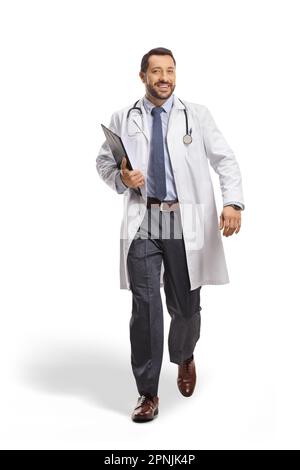 Smiling male doctor holding a clipboard and walking towards camera isolated on white background Stock Photo
