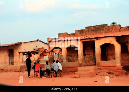 Men are seen at sunset playing a game at Malingunde centre. Playing games is a past time favourite on Sunday afternoons. Malawi. Stock Photo