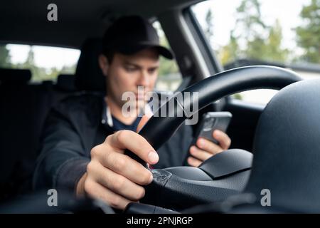 Driving car and using phone to text. Driver using cellphone. Accident, crash and danger in traffic. Man texting with mobile app. Stock Photo