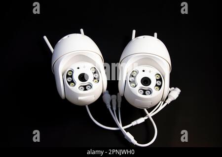 Two white IP cameras placed on a black background Stock Photo