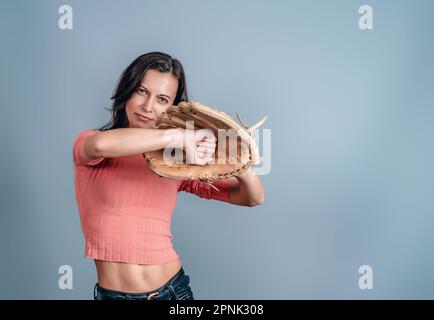 Slender woman holding baseball glove in her hand Stock Photo