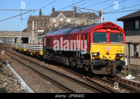 DB Cargo liveried class 66 shed diesel-electric loco 66104 on West Coast Main Line at Carnforth with civil engineers train 19th April 2023. Stock Photo