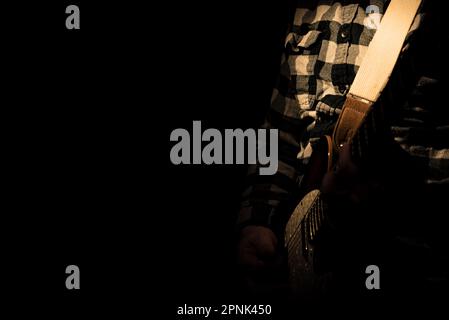 Guitarist on stage for background, soft and blur concept. Close up hand playing guitar. young musician playing guitar, live music background Stock Photo