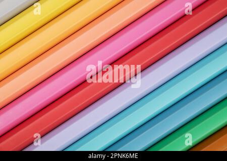 Colored pencils of pastel colors on a pink background. Abstract pencil background. Multi-colored pastel pencils. Stock Photo