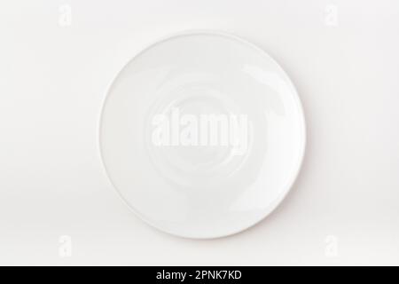 An empty white plate on a white background. Blank plate. Top view. Stock Photo