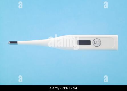 Digital thermometer levitating on a blue background. Stock Photo